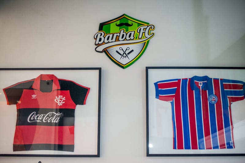 Camisas de Vitória e Bahia emolduradas na parede da Barba FC